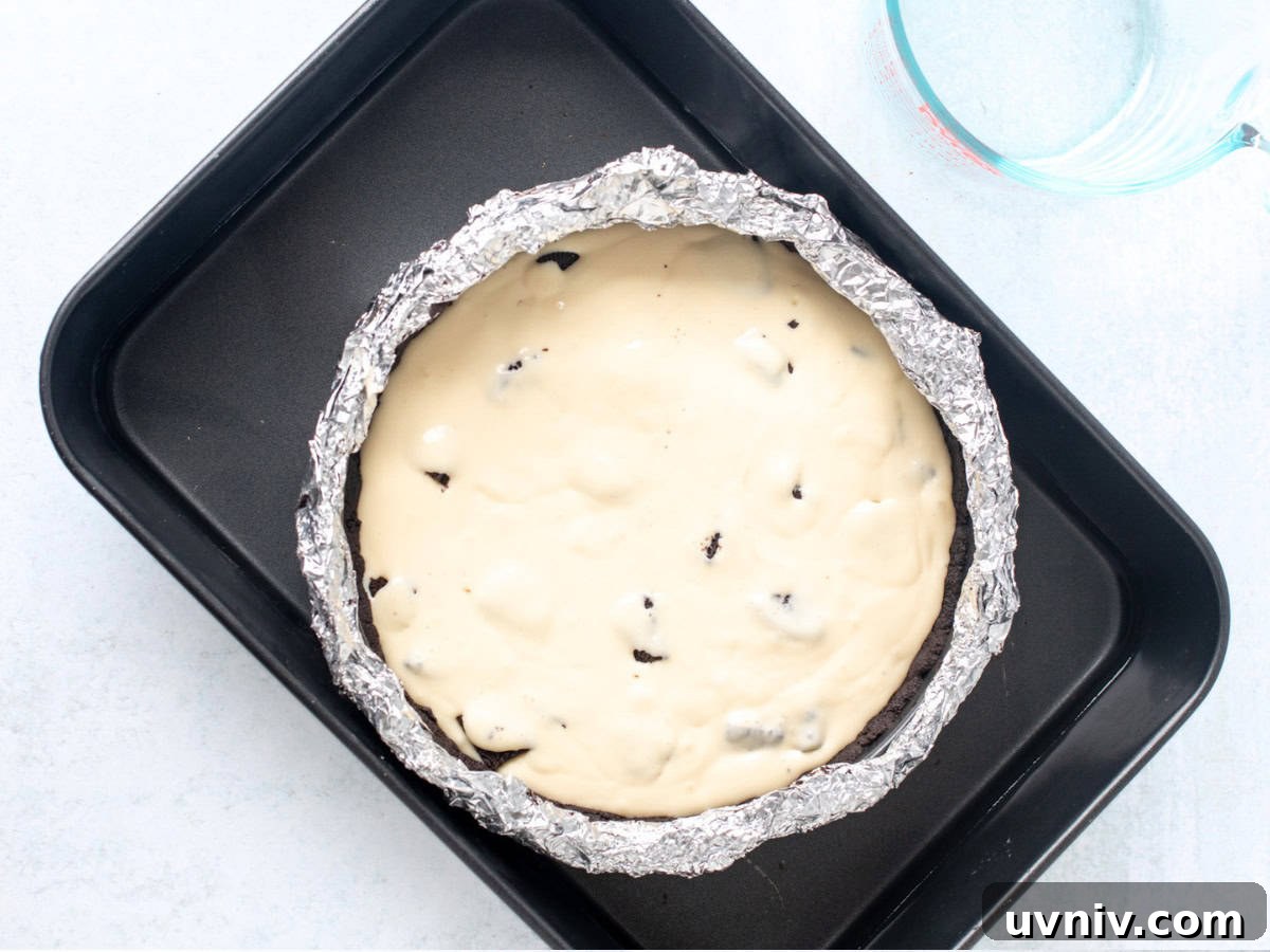 Decadent Oreo Cheesecake Recipe: Creamy Cookies & Cream Dessert 5 Unbaked Oreo cheesecake in a water bath.