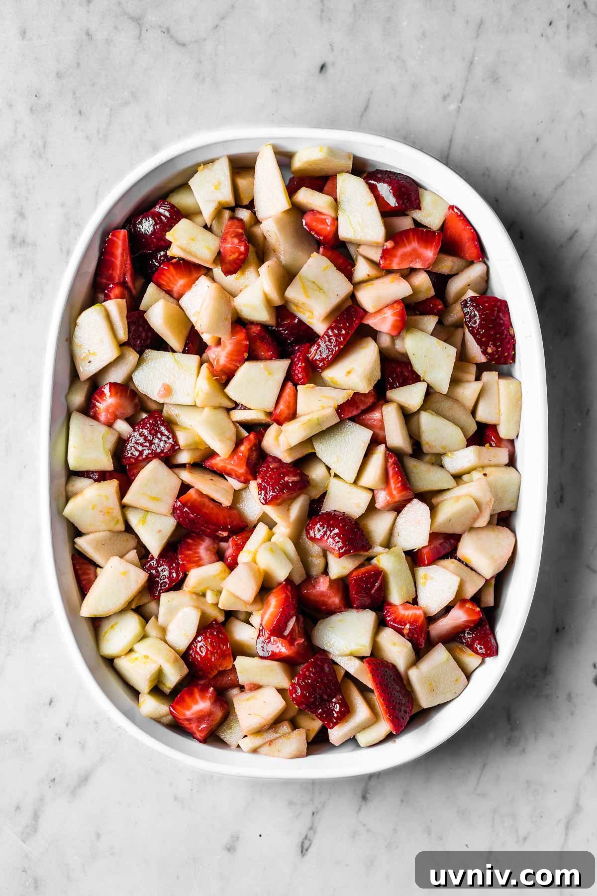 A dish of unbaked strawberry apple filling.