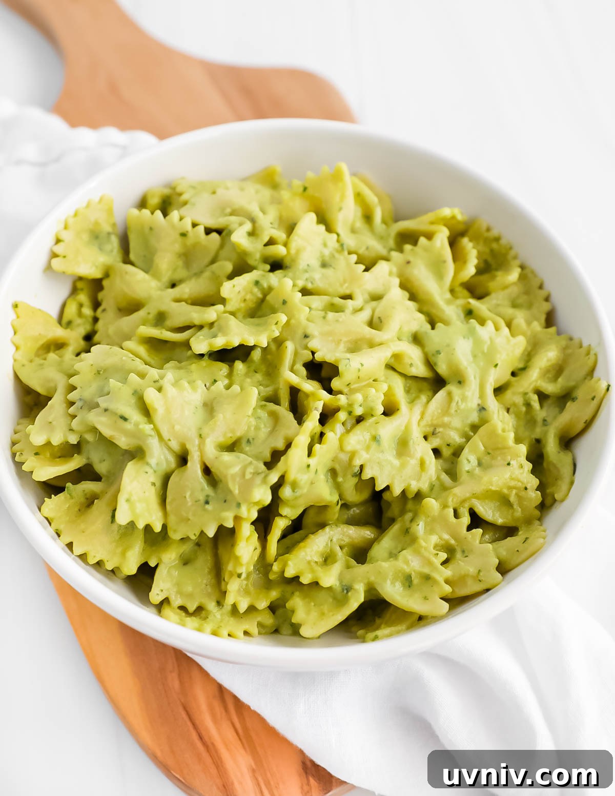 Creamy Lemon Herb Tahini Sauce Recipe for Salad & Dips 7 A bowl of bowtie pasta covered in a green cream sauce.