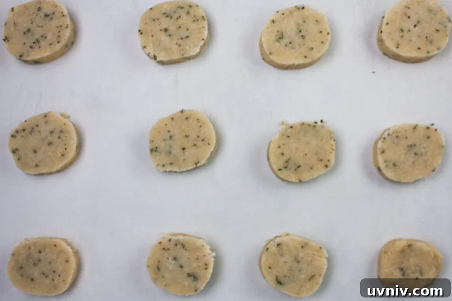 Parmesan Rosemary Shortbread rounds on a parchment lined baking sheet.