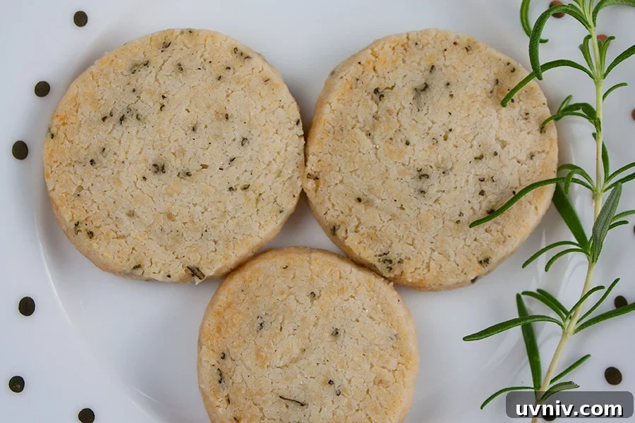 Savory Parmesan Rosemary Shortbread on a white plate garnished with fresh rosemary sprig.