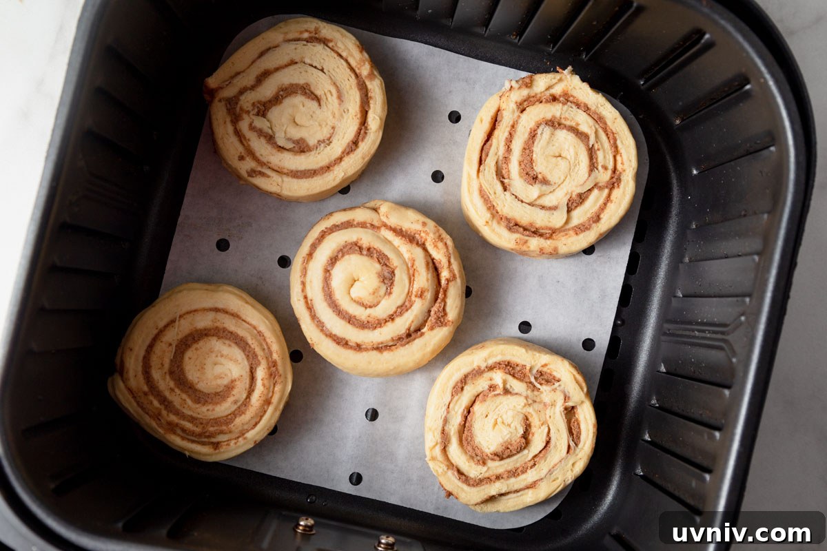 Pillsbury Cinnamon Rolls in the Air Fryer: Quick & Fluffy 4 pillsbury cinnamon rolls in the air fryer ready to be baked.