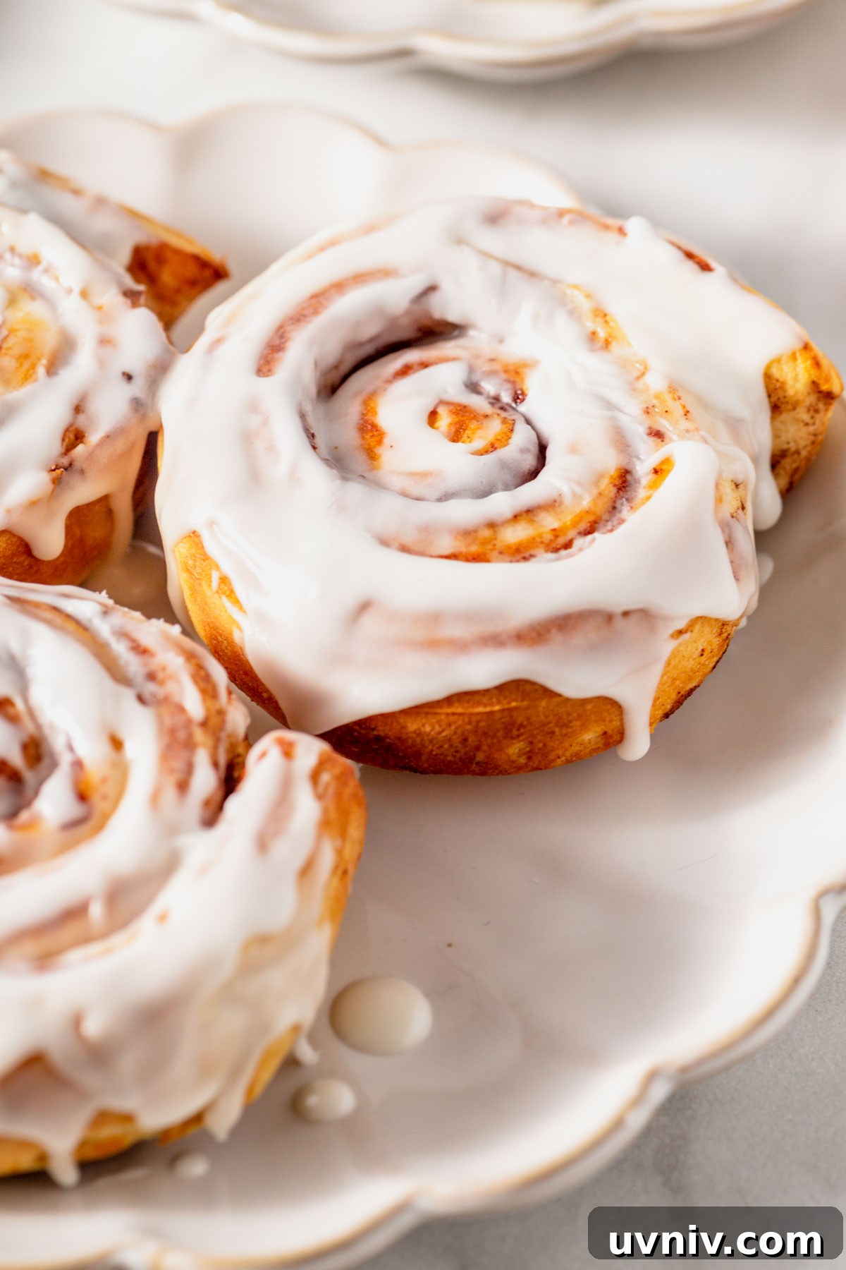 Pillsbury Cinnamon Rolls in the Air Fryer: Quick & Fluffy 7 iced air fryer cinnamon rolls on a plate.