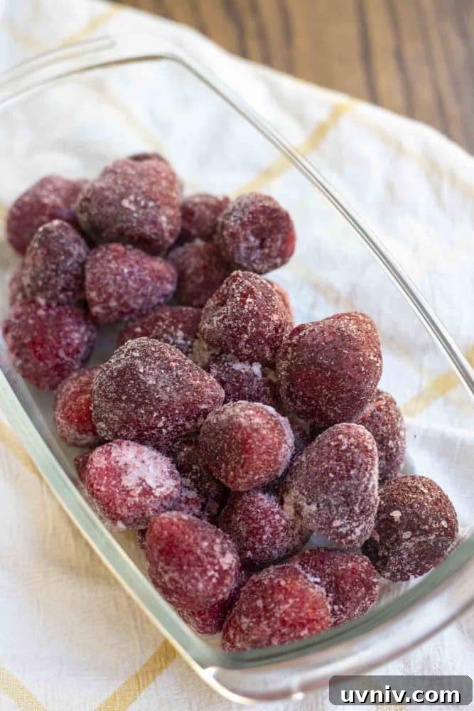 Freeze Strawberries Properly: Step-by-Step Guide for Fresh Flavor 12 frozen strawberries in a glass dish on a white and yellow checked towel