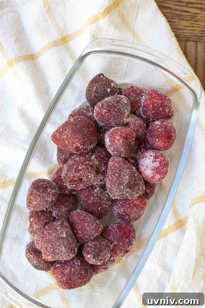 Freeze Strawberries Properly: Step-by-Step Guide for Fresh Flavor 4 overhead photo of frozen strawberries in a glass dish on a white and yellow checked towel