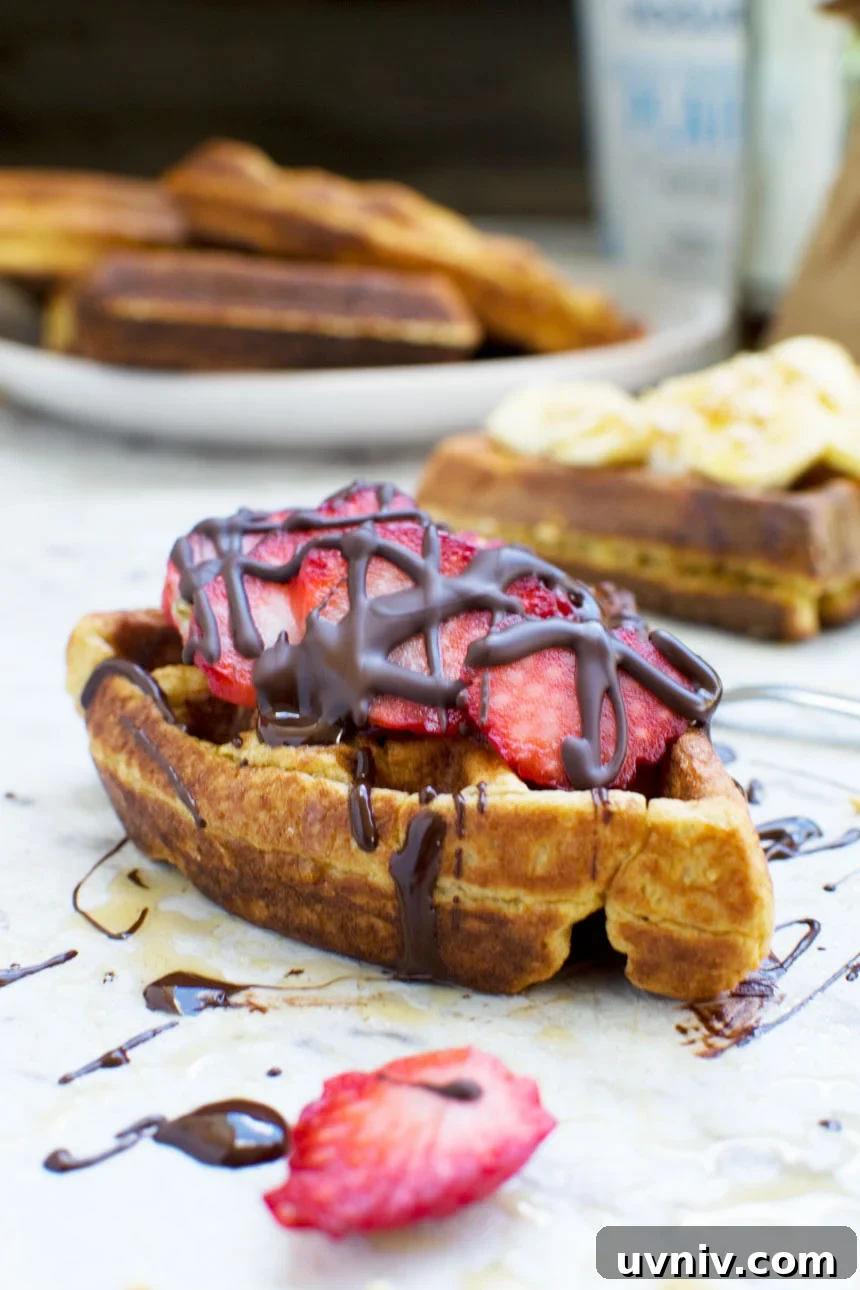 Banana Bread Waffles That Transform Your Weekend Brunch 6 A banana bread waffle segment topped with sliced strawberries and drizzled chocolate