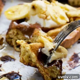 Banana Bread Waffles That Transform Your Weekend Brunch 7 A piece of banana bread waffle on a fork with the rest of the waffle in the background