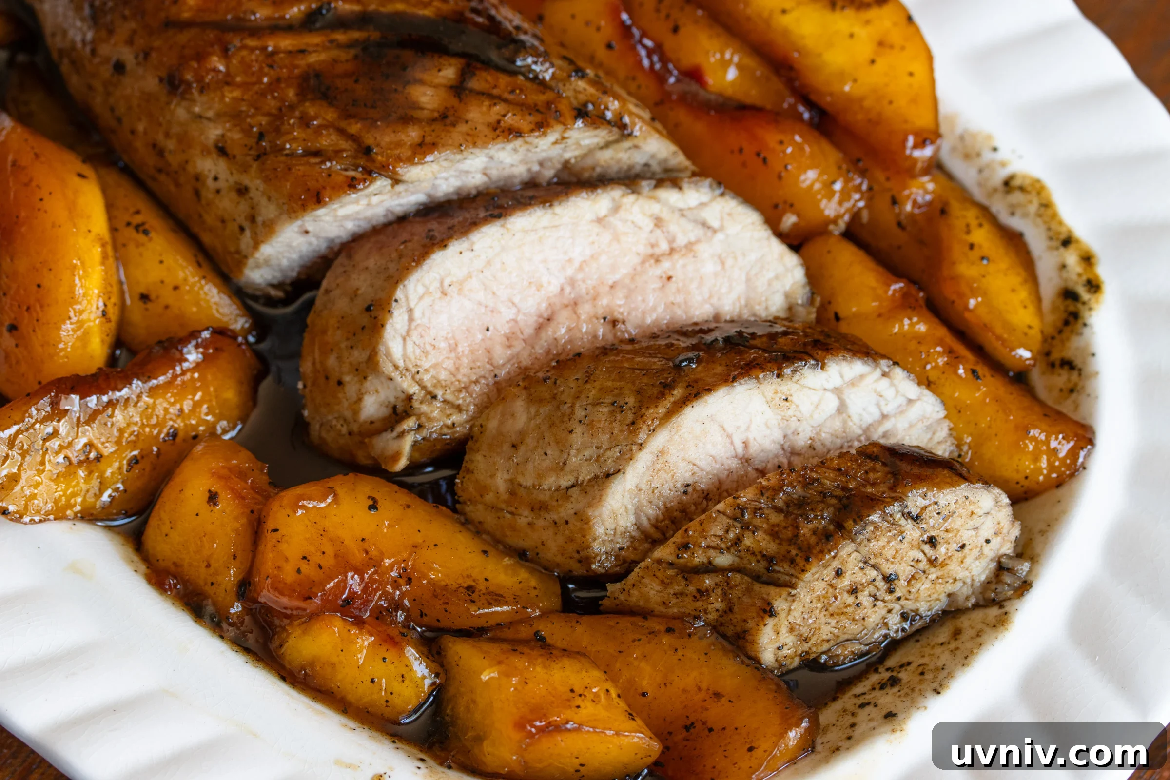 Sliced pork surrounded with peaches.