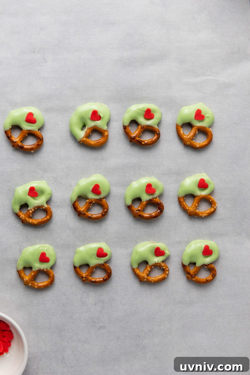 Placing red heart on chocolate covered pretzel