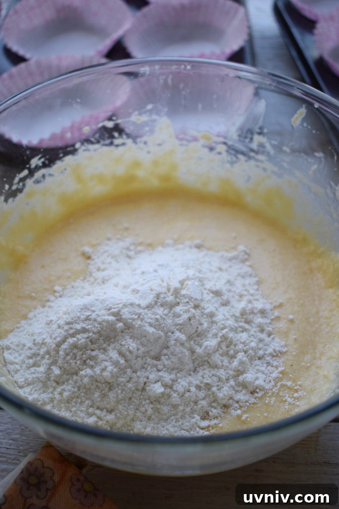 adding flour to cake batter