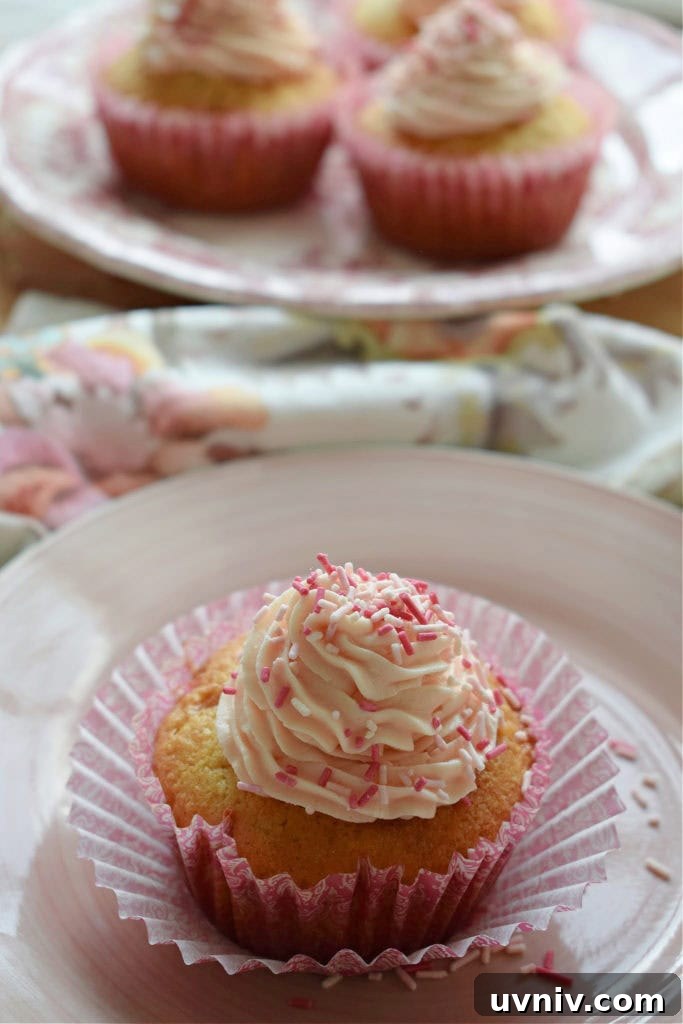Fresh Strawberry Cupcakes with Buttercream frosting on a plate and some in the background