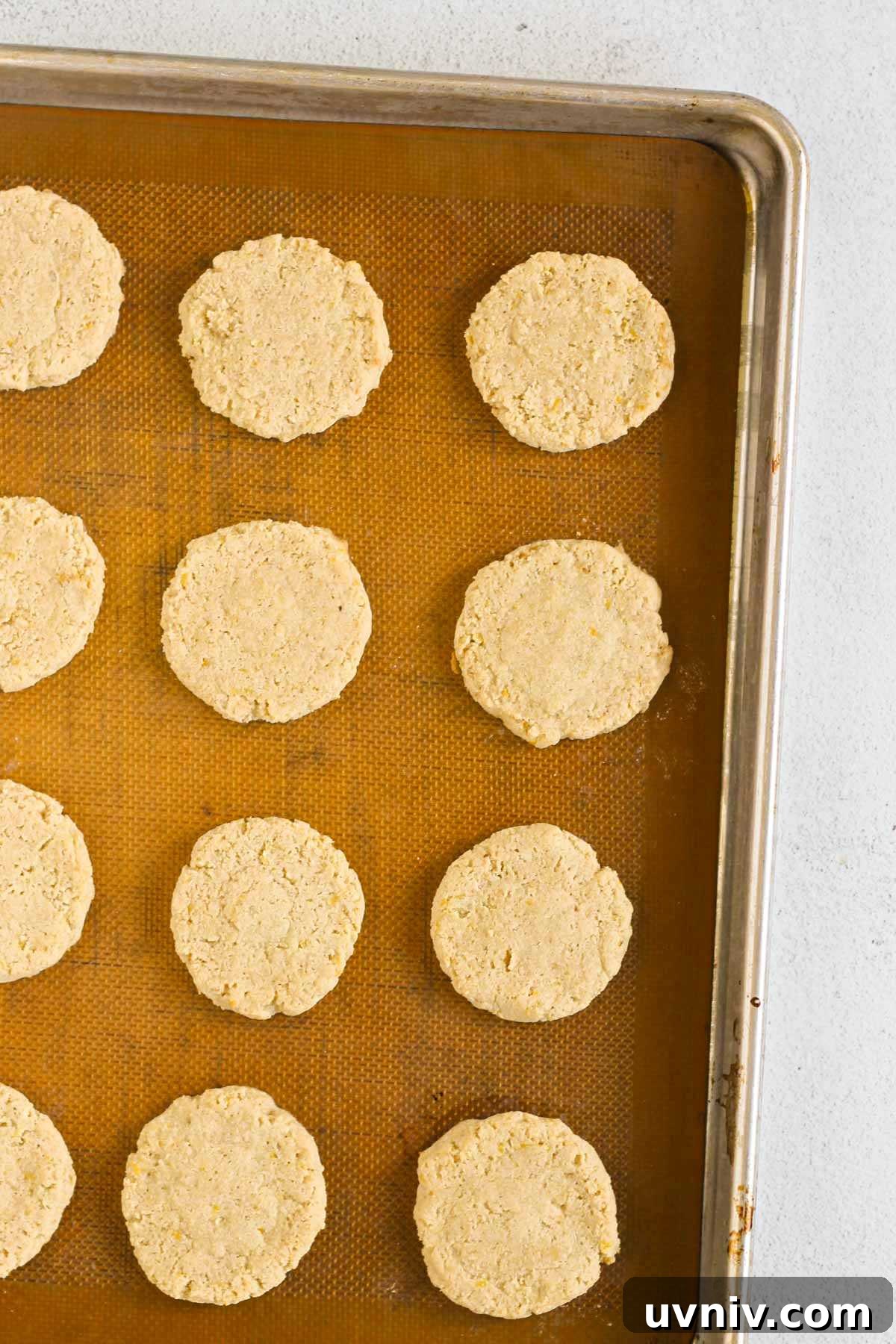 Baked almond flour cookies on a silicone mat lined baking sheet.