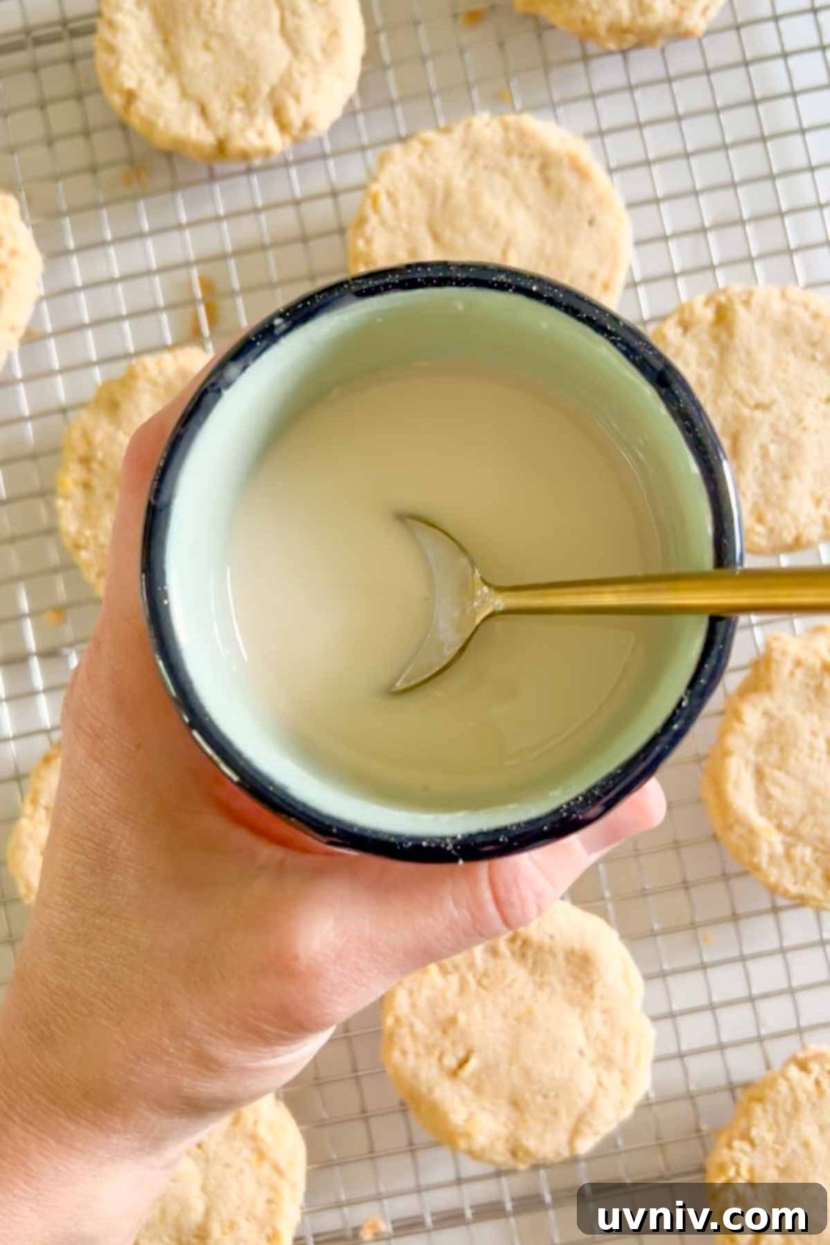 Powdered sugar glaze mixed in a small bowl with a spoon in the bowl.