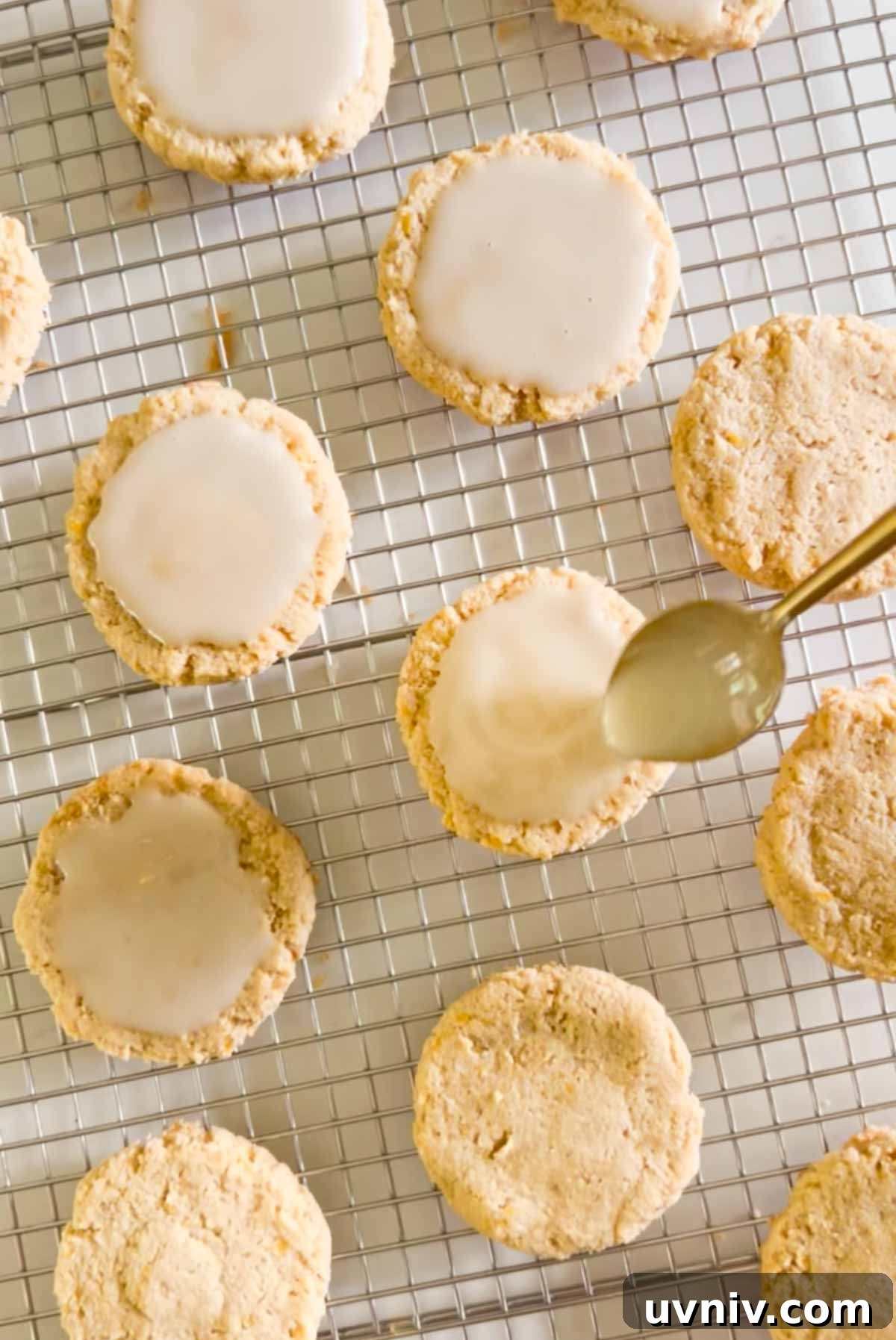 Spoon spreading glaze on top of an almond flour cookie.