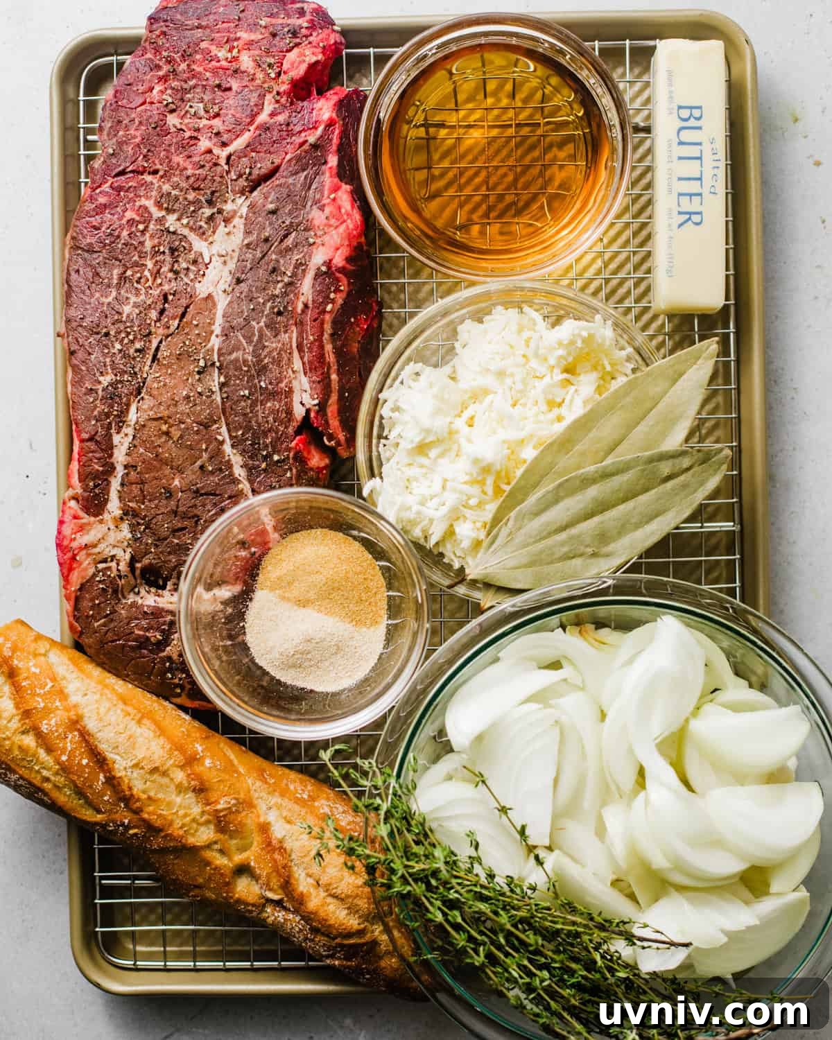 ingredients to make french onion pot roast -  chuck roast, onions, thyme, whiskey, red wine,  baguette, butter, gruyere cheese, beef bouillon paste, tomato paste, and garlic. 