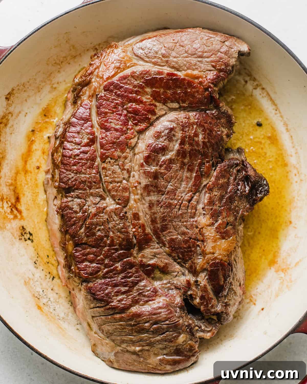 seared chuck roast in a braising pan. 